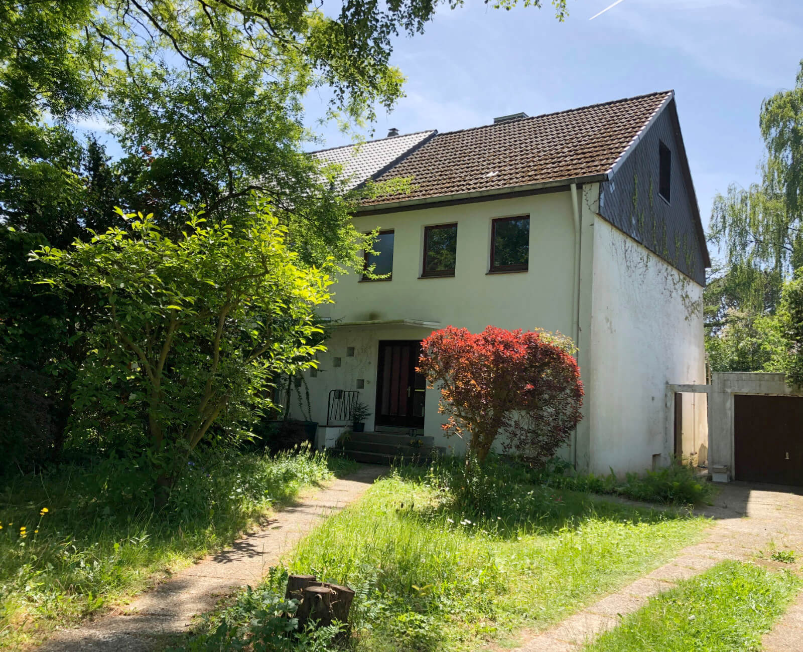 Das Haus vor der Sanierung mit alter Fassade, Fenstern und Ziegeldach